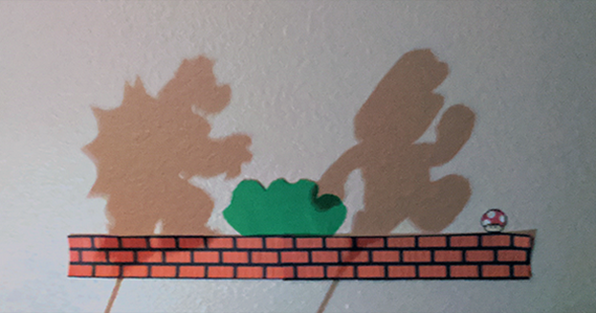 Shadow puppet scene with Mario and Bowser running across a ledge