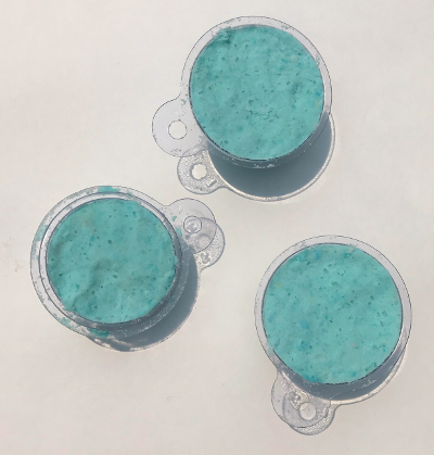Plastic molds are packed with a blue powdered mixture