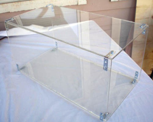 A rectangular prism made of Plexiglas is held together with silicone and corner brackets