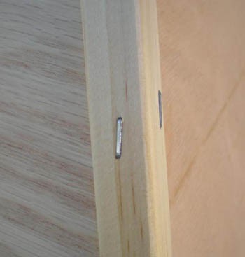 Close up photo of wooden corner guards stapled to a corner